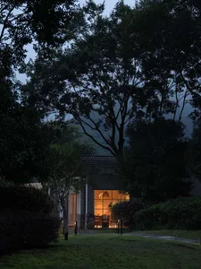Modern house with wooden exterior and glass windows at dusk.