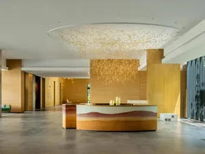 A modern lobby features a wooden reception desk with a unique design element.