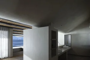 Modern residential bathroom with concrete walls, floor, and ceiling, featuring a minimalist design.
