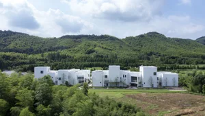 Modern residential building with white concrete exterior and geometric design.
