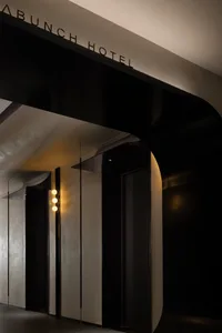 Modern, black and white hotel entrance with metallic accents and concrete walls