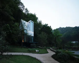 A modern house with glass cabinets and a gravel path.
