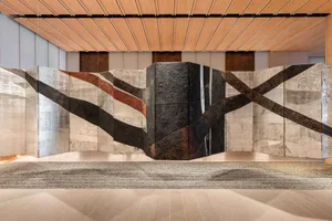 Modern lobby featuring decorative concrete, metallic accents, and leather textures.