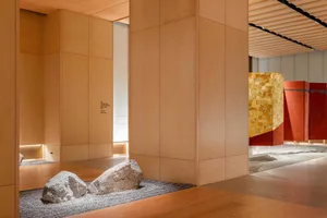 A minimalist lobby with wooden walls and rocks in the floor.