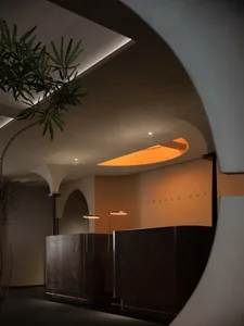 A sleek, modern hotel reception desk with wooden and concrete materials in a luxurious interior space.