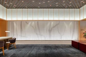 A minimalist office lobby featuring a glass waterfall installation.