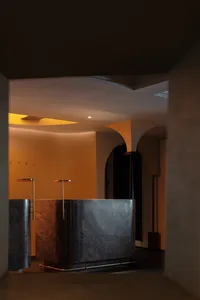 A modern reception desk made of marble in a hotel lobby.