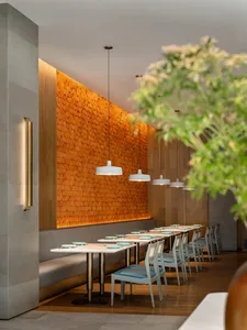 A modern restaurant interior featuring industrial design elements such as concrete walls, wooden shelves, and porcelain plate