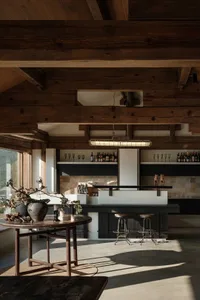 An industrial-style bar with wooden beams and concrete flooring.