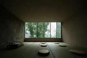 Minimalist room with wooden furniture and stone wall