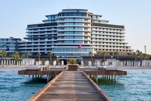 Modern hotel buildings with glass facades and wooden decks on the Adriatic Sea.