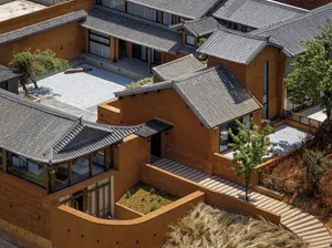 A modern residential exterior featuring a terra-cotta roof and exterior walls.