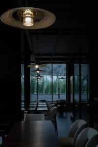 Modern restaurant interior with wooden tables and leather chairs.