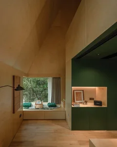 Modern cozy lounge with wooden walls, high ceiling, and green accents.
