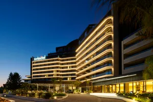 Swissotel hotel building illuminated at night with modern architectural design.