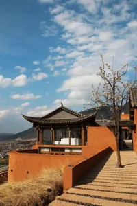 A traditional terracotta residence with a curved roof and steps leading to it.