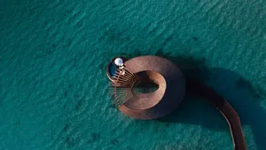 Aerial view of a wooden structure on the water's edge.