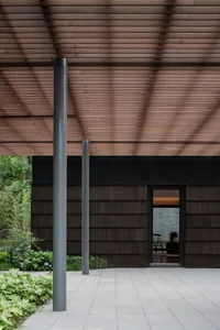 Modern minimalist building exterior with wooden siding and large windows.