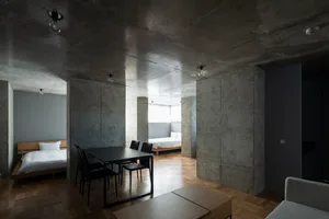 A modern bedroom with concrete walls and minimalist furniture.