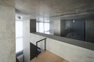 A modern building interior with concrete walls and wooden floors.