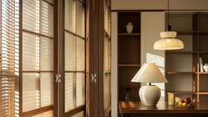 A well-lit living room featuring wooden flooring and a wooden table with a lamp and decorative items.