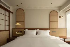 A minimalist bedroom with textured wood headboards and woven fabric accents.