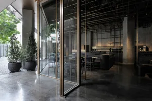A modern minimalist restaurant interior with concrete materials and a sleek, industrial design.