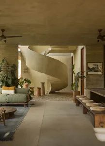 An industrial-style residential interior featuring a spiral staircase made of concrete.