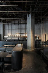 工業風格餐廳酒吧，採用混凝土、玻璃與金屬材質。