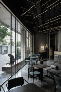 現代工業風餐廳室內，採用金屬與混凝土元素，並搭配大型窗戶。