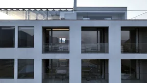 A modern minimalist building with glass terraces