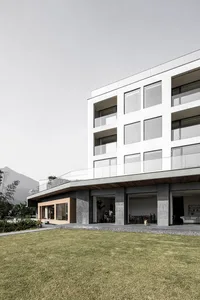 現代住宅公寓大樓，混凝土外牆搭配大型窗戶。