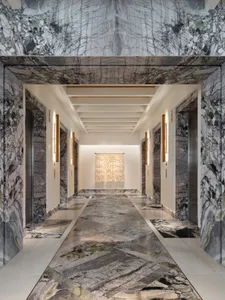 A long, elegant hallway with marble floors and walls, and a unique glass art installation at the end.