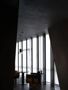 A modern lobby space featuring glass and concrete materials.