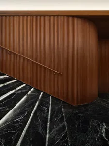 Modern staircase with black marble and wooden walls featuring a scroll design.