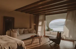 A minimalist bedroom featuring curtains and wooden furniture.