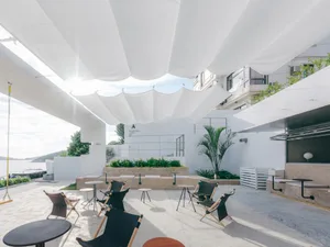 Minimalist outdoor seating area with concrete, metal, and fabric