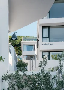 Modern minimalist buildings constructed from white concrete, glass, and metal materials.