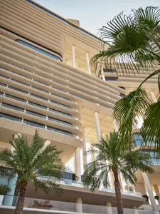 Modern architecture featuring concrete structure and palm trees.
