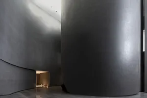 A modern lobby featuring industrial-style concrete walls and floors.