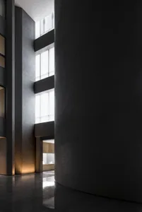 Modern industrial style lobby with dark concrete walls and lighting.