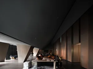 A modern minimalist lobby featuring marble and wood materials.