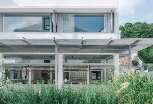 The contemporary design of a residential building featuring raw concrete materials and a minimalist aesthetic.