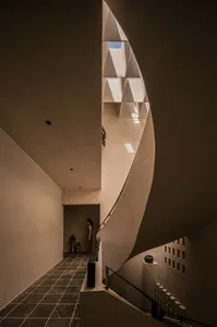 Modern staircase with concrete walls and floors, featuring geometric shapes and industrial design elements.