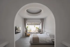 Modern minimalist bedroom featuring a textured concrete floor and wall.