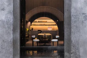 A modern dining room with a concrete and glass palette