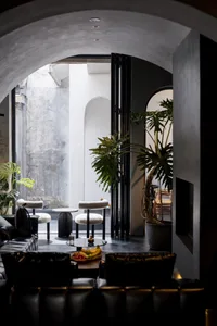 A modern restaurant lounge with concrete, leather, and glass materials.