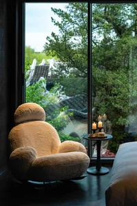 A plush, contemporary window seat with a soft, textured fabric in a minimalist bedroom setting.