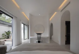 Modern minimalist bedroom with concrete finishes, large windows, and organic elements.