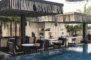 Poolside bar with wicker furniture and concrete bar counter